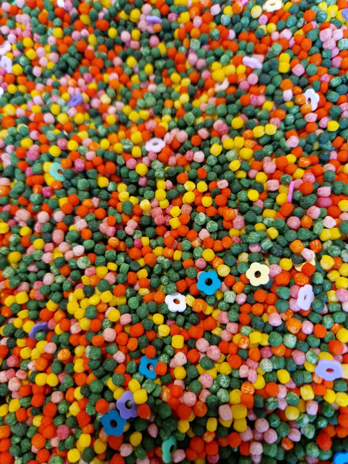 Sensorische mix Lente met gekleurde parelcouscous en plastic bloementjes